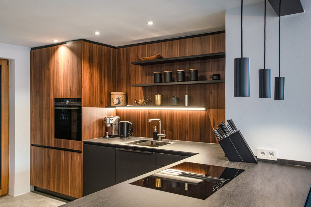 Moderne Küche mit schieferschwarzen Fronten kombiniert mit Nussbaumholz