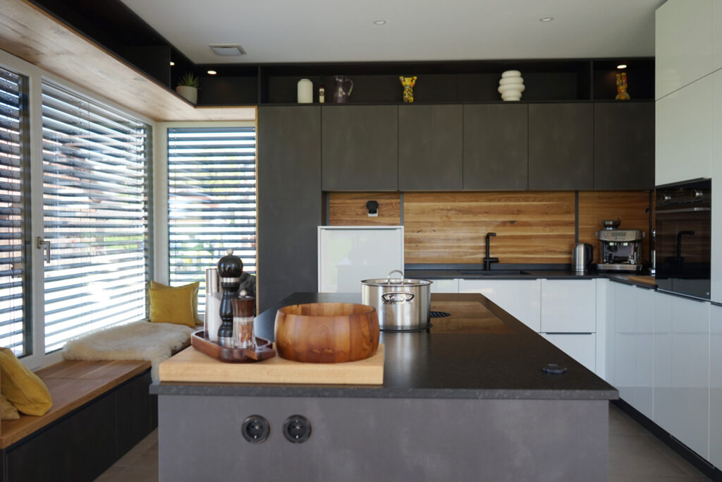 dunkle Echtholz arbeitsplatte in einer Küche. auf dem Herd steht ein Topf. Im Vordergrund eine Holzschale und Gewürze